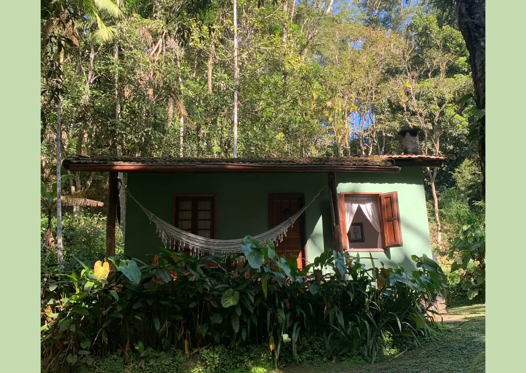 Chalé verde com rede na varanda