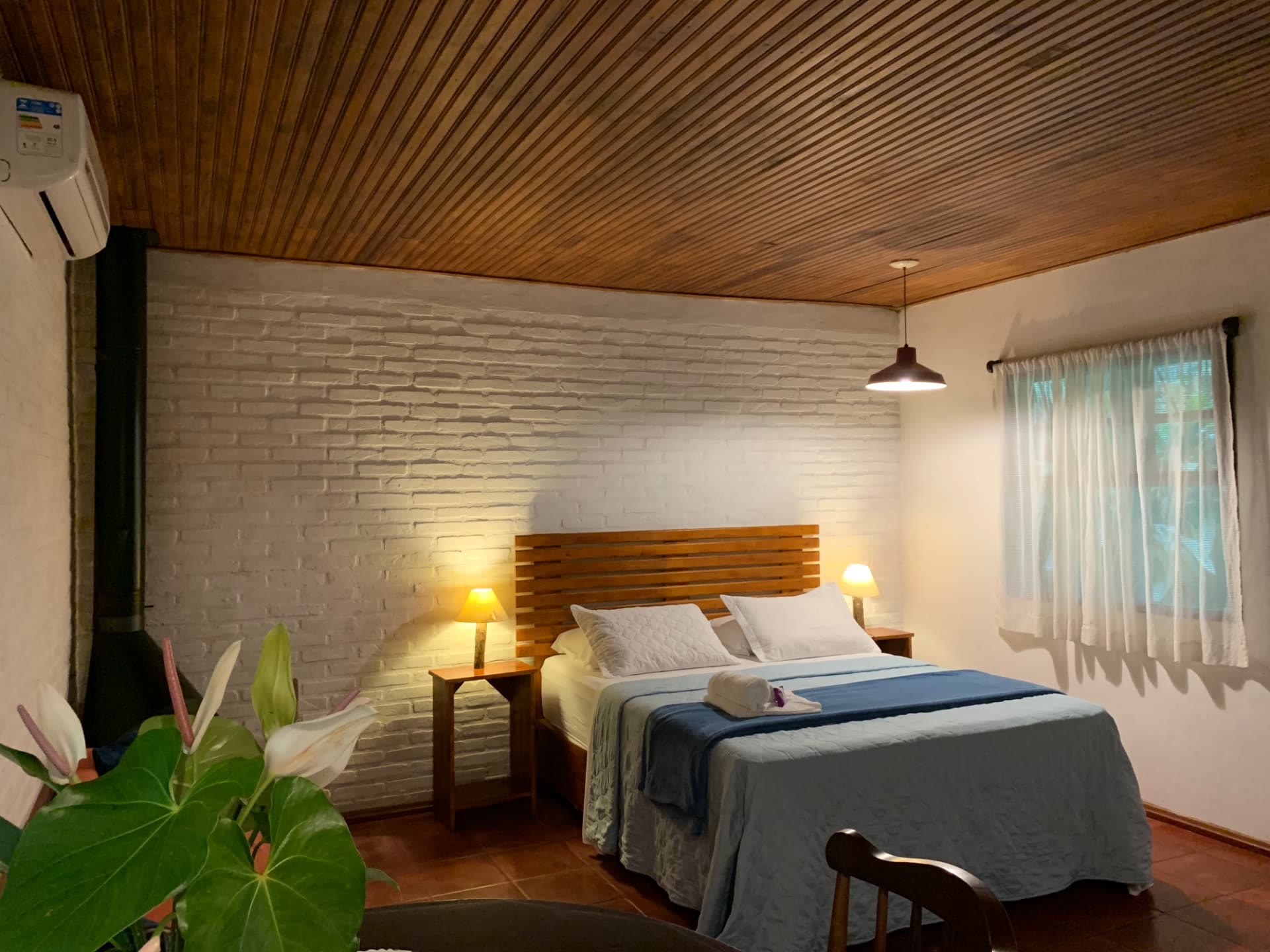 Quarto com parede de tijolinho branco